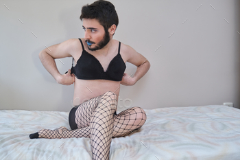 Young man wearing fishnet stockings and bra. stock photo NULLED