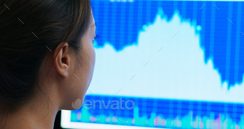 Woman look at the stock market data on computer monitor stock photo NULLED