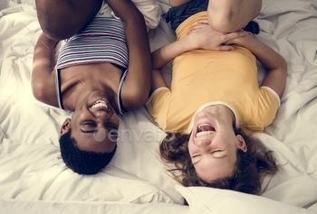 Women lying on the bed and laughing stock photo NULLED