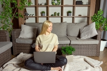 A woman works  at her laptop at home as a freelancer stock photo NULLED