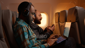 African american freelancer using laptop on flight