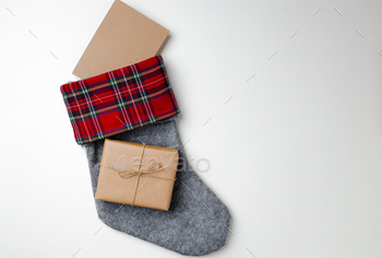 Christmas stocking with wrapped gift on white background stock photo NULLED