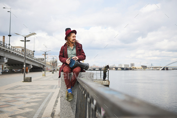 Delighted freelancer making music on the embankment stock photo NULLED