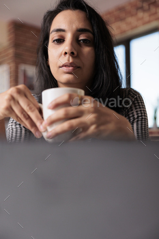 Female freelancer doing remote work on laptop stock photo NULLED