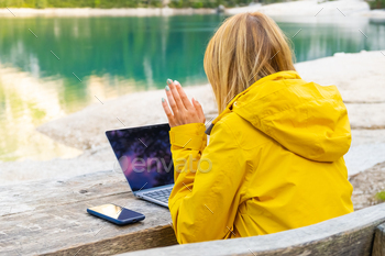 Freelancer having a video call near the lake stock photo NULLED