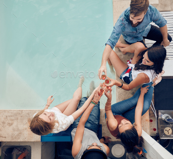 Group of friends toasting at poolside party stock photo NULLED