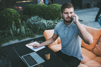 Man freelancer working on computer on terrace stock photo NULLED