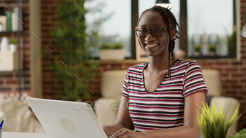 Portrait of female freelancer working on laptop at home stock photo NULLED