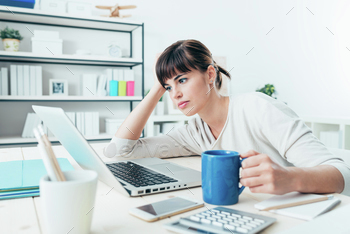 Tired woman at office desk stock photo NULLED