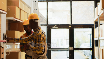 Two people working on stock inventory in storehouse stock photo NULLED