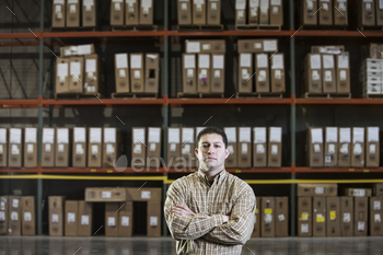 Warehouse worker by a rack of stock in a distribution warehouse.