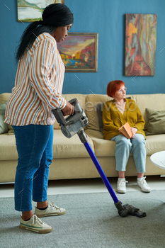 Woman helping to elderly woman in housework