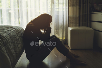 depressed woman sitting in the dark bedroom stock photo NULLED