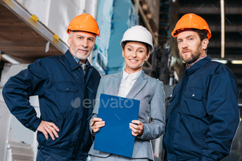 male workers and female inspector in helmets in shipping stock stock photo NULLED